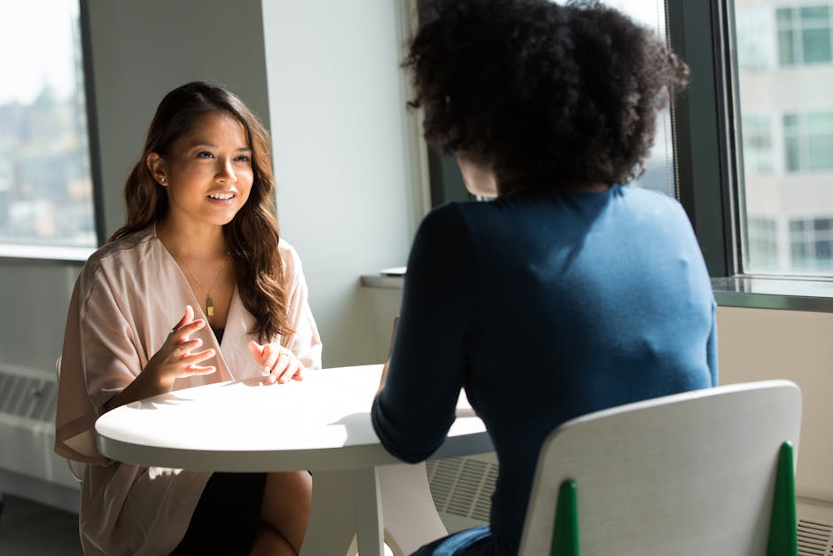 Professional business coaching session - Two women having a productive discussion in a bright office setting